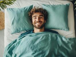 Man waking up happy in a cozy bed with green pillows photo