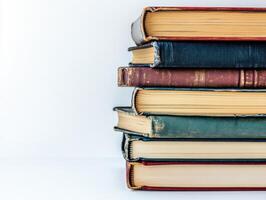 Stack of vintage books on a plain background showcasing worn edges photo
