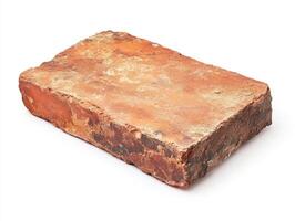 Old red brick resting on a plain surface photo