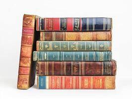 Vintage leather-bound books stacked on a white background photo