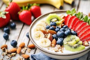 Colorful fruit and yogurt bowl with granola on wooden table photo