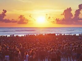Crowd watching sunset on beach with vibrant orange sky photo