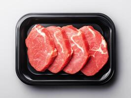 Fresh cuts of pork arranged neatly in a black tray photo