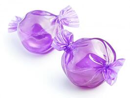 Colorful purple candy wrapped in shiny plastic on white background photo