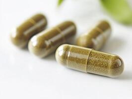 Herbal capsules arranged on a clean surface with green background photo