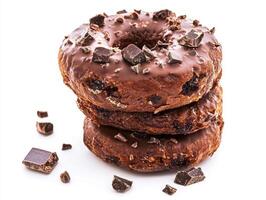 Delicious chocolate glazed donuts stacked with chocolate chunks photo