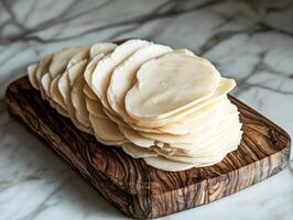 Sliced cheese on a wooden board ready for serving photo