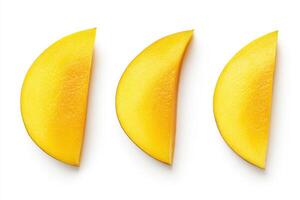 Bright yellow mango slices arranged in a row on a white background photo