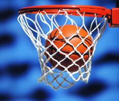 Basketball swishing through hoop on a sunny day photo