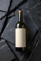 Wine bottle lying on dark stone tiles with blank label for customization photo