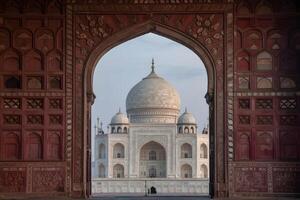 Taj mahal emerging from a red stone archway in agra, india photo