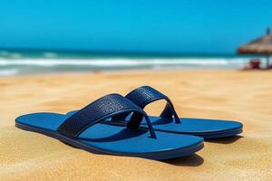 Blue flip flops resting on sandy beach by ocean on sunny day photo