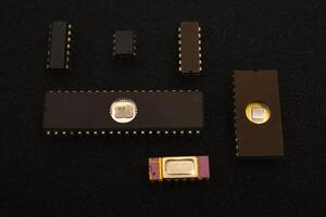 Vintage microchips arranged on dark foam background.Several microchips on black foam. Old integrated circuits for radio electronics. photo
