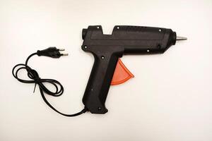 A tool for gluing. Black glue gun on a white background. photo