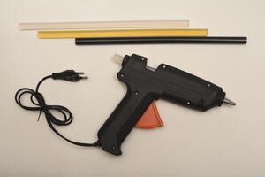 Black glue gun on a white background. A tool for gluing. photo