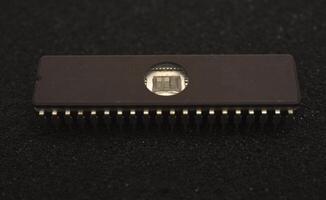 Antique silicon chips with metallic pins. The microcircuit is on black foam. An integrated circuit for radio electronics. photo