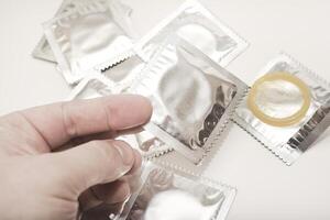 Discreet Packaging, Confident Choice. An open condom in a package. Male contraceptives. The condom is in your hand. photo