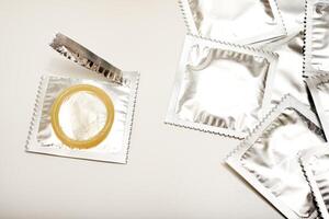 An open condom in a package. Male contraceptives. Enhanced Sensitivity, Natural Feel. photo