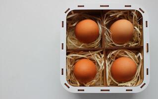 Design for an Easter card featuring brown eggs inside a handmade square wooden basket with compartments filled with delicate shavings photo