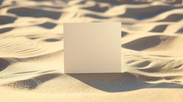 A blank square card on the sand, with shadows and ripples of sunlight. 12 photo