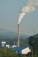 Smoke coming out of factory chimneys causes air pollution to pollute the environment. Carbon dioxide emissions from factory waste. Concept of global warming and climate change. photo