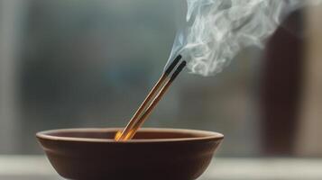 Incense sticks releasing smoke in a ceramic holder, creating a tranquil atmosphere indoors photo