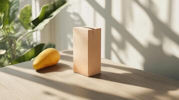 Bright morning light illuminates a mango and a cylindrical container on a wooden table in a serene indoor setting photo