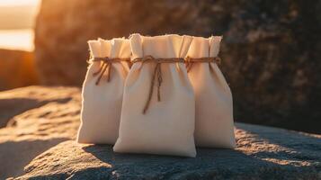 Fabric bags arranged on a rock during sunset by the ocean with a warm glow creating an inviting atmosphere photo