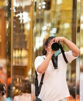 Photographer using camera to taking Self Portrait in4 the mirror.Photographer with a black SLR camera. photo