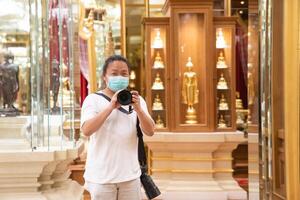 Photographer using camera to taking Self Portrait in 1the mirror.Photographer with a black SLR camera. photo