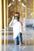 A man wearing black mask is shooting photo through a viewfinder camera with the right eye.4