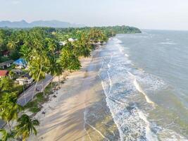 The ariel view of the clear sky with palm trees, fine sand and foam waves splashed to serene beach in Chumphon, Thailand.1 photo