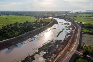 Construction dredges up for a canal and dam, to prevent a flood in the rainy season. Date on 14 May 2021 at Uthai Thani province, Thailand.1 photo