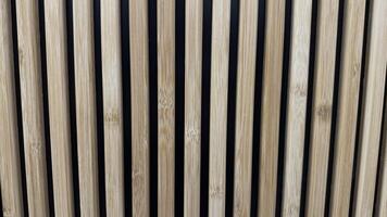 Close-up view of vertical wooden slats evenly spaced against a dark background, showcasing texture, alignment, and minimalism, suitable for modern and natural design concepts. Can be used like background. photo