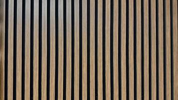 Vertical Wooden Slats Creating a Patterned Architectural Design on Indoor Walls. Vertical wooden slats form a visually appealing architectural wall design, enhancing interior aesthetics and texture. photo