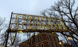 A glowing neon sign marks the entrance to New Holland, a historic district in Saint Petersburg. photo