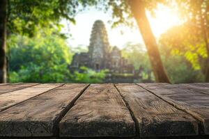 light wooden table foreground with blurred tropical temple ruin surrounded by dense jungle and sunlight breaking through trees photo