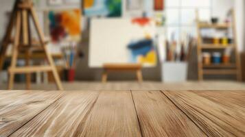 Empty cherry wood tabletop front of softly blurred art studio interior with colorful canvases, paint splatters, and scattered photo