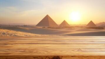 Empty oak tabletop in front of softly blurred desert landscape with distant ancient pyramids and golden hour lighting photo
