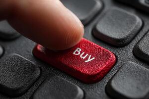 Finger presses buy button on computer keyboard photo