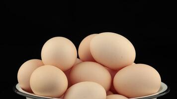 A bowl full of eggs on a black background video
