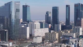 Aerial view of Warsaw, Poland, featuring the Palace of Culture and Science, Zlota 44, and modern high rises with a gradual panning motion under clear skies. video