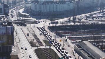 Aerial view of Warsaw, Poland, showing a busy urban area with moving trams, cars, train tracks, a dome building, and patches of snow in winter. video