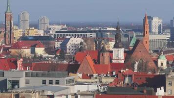 Aerial view of Wroclaw, Poland, featuring the Wroclaw Cathedral spires, red rooftops, historic architecture, and modern city elements in smooth motion. video