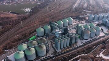 Metal silos on field aerial view. Large containers for storing and processing grains. Silver grain elevators in farmland. Storage tank view from above. Silo with grain. 4 video