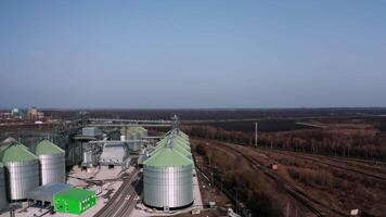 Metal silos on field aerial view. Large containers for storing and processing grains. Silver grain elevators in farmland. Storage tank view from above. Silo with grain. 9 video