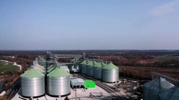Silos on field aerial view. Large containers for storing and processing grains. Silver grain elevators in farmland. Storage tank view from above. Silo with grain. video