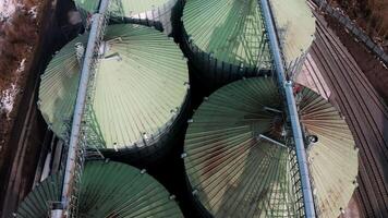 Metal silos on field aerial view. Large containers for storing and processing grains. Silver grain elevators in farmland. Storage tank view from above. Silo with grain. 15 video