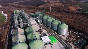 Field aerial view on the large containers for storing and processing grains. Silver grain elevators in farmland. Storage tank view from above. Silo with grain. 3 video