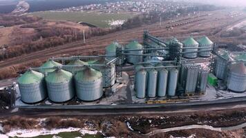 Metal silos on field aerial view. Large containers for storing and processing grains. Silver grain elevators in farmland. Storage tank view from above. Silo with grain. 16 video